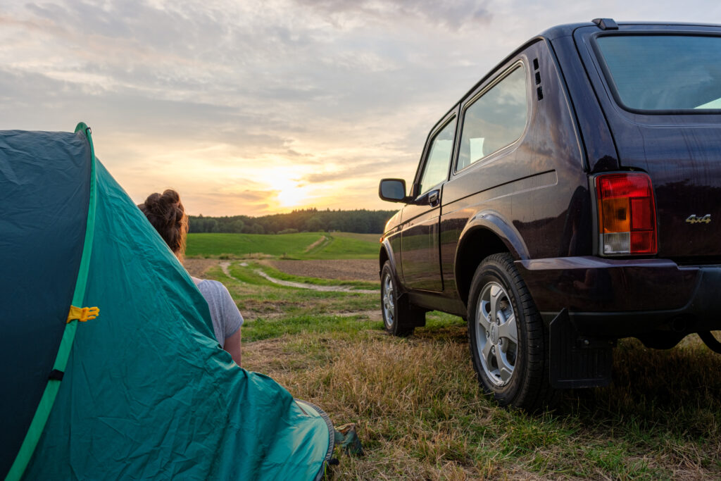 Paar unterwegs mit Lada und Zelt