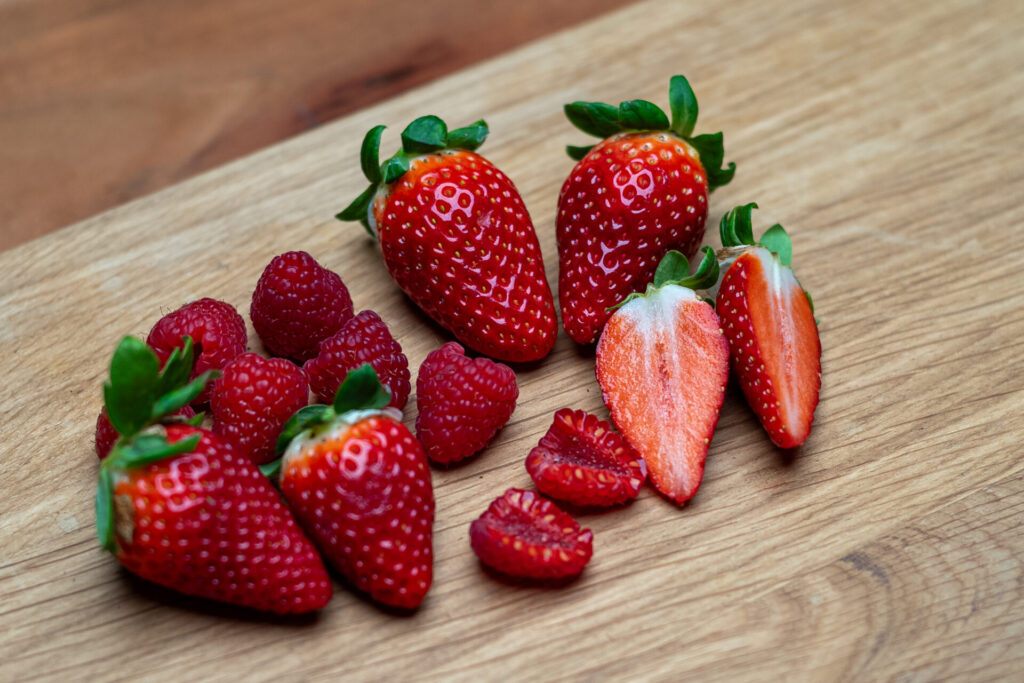 Erdbeeren und Himbeeren auf Holzbrett